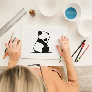 Pochoir animaux mignons panda assis peint noir au crayon, atelier bols peinture règle métal