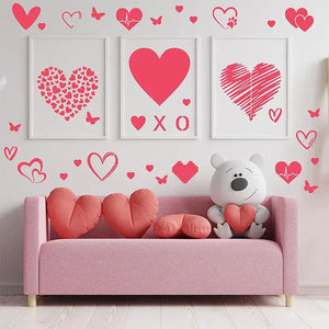 Pochoir coeur trois cadres encadrés rose framboise sur mur clair, sofa et nounours porteur coeur