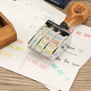 Tampon dateur scrapbooking en action, dates imprimées en plusieurs couleurs sur papier