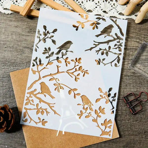 Dessin pochoir animaux oiseaux sur branches feuillues, planche découpée et enveloppe kraft