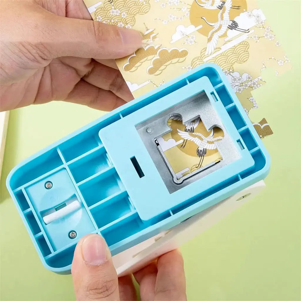 Perforatrice découpant une pièce de puzzle dans du papier doré