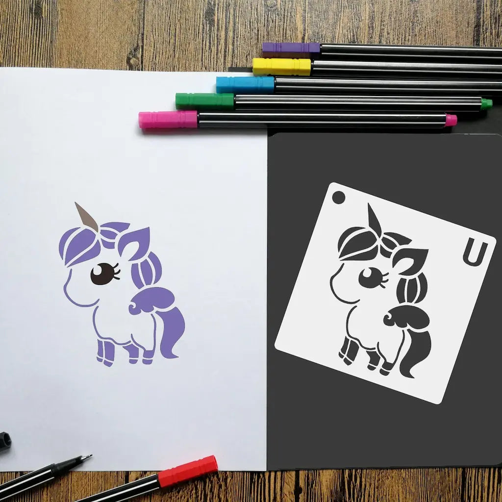 Pochoir animaux cartoon poney violet coloré au feutre, planche U noire à côté sur table bois