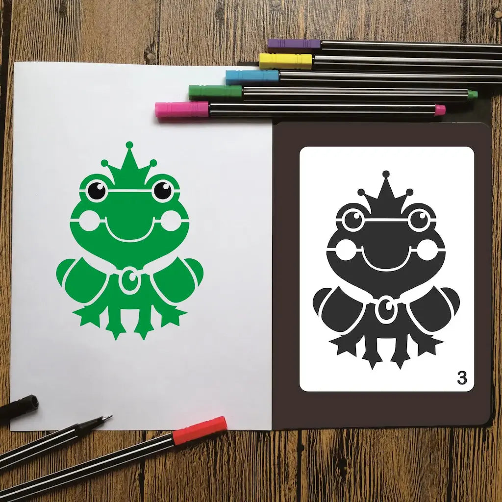 Pochoir animaux grenouille couronne peinte vert sur papier, planche noire à côté marqueurs
