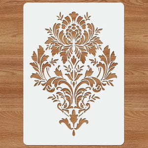 Pochoir baroque posé sur planche bois clair, motif damassé floral central découpé