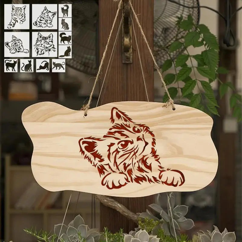 Pochoir chats motif rouge sur plaque bois suspendue, fond végétal en extérieur