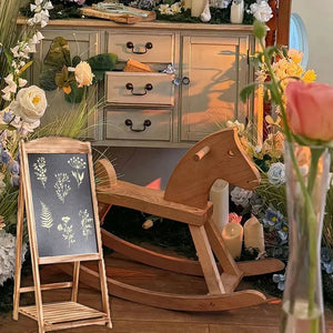 Pochoir fleur peint blanc sur tableau noir et chevalet bois, cheval à bascule en décor