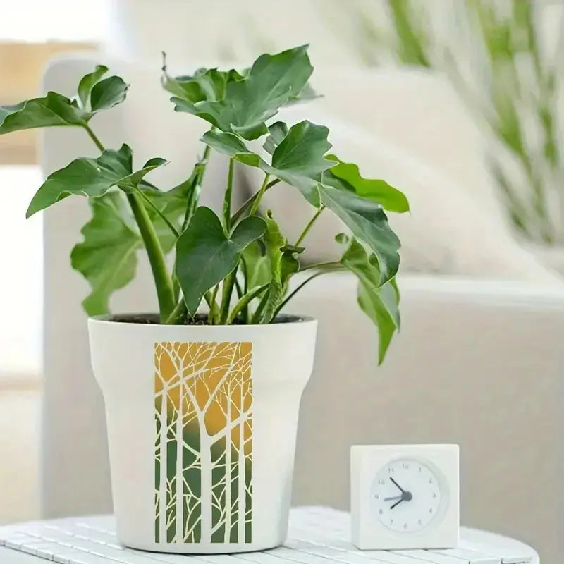 Pochoir floral décoratif arbres au crépuscule sur pot de plante, philodendron et horloge