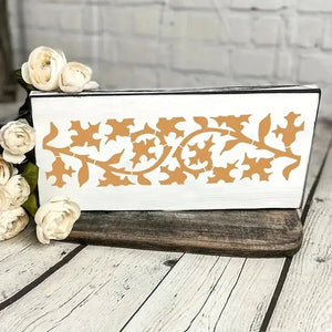 Pochoir frise florale lierre orange peint sur bloc bois blanc, roses pâles en accent