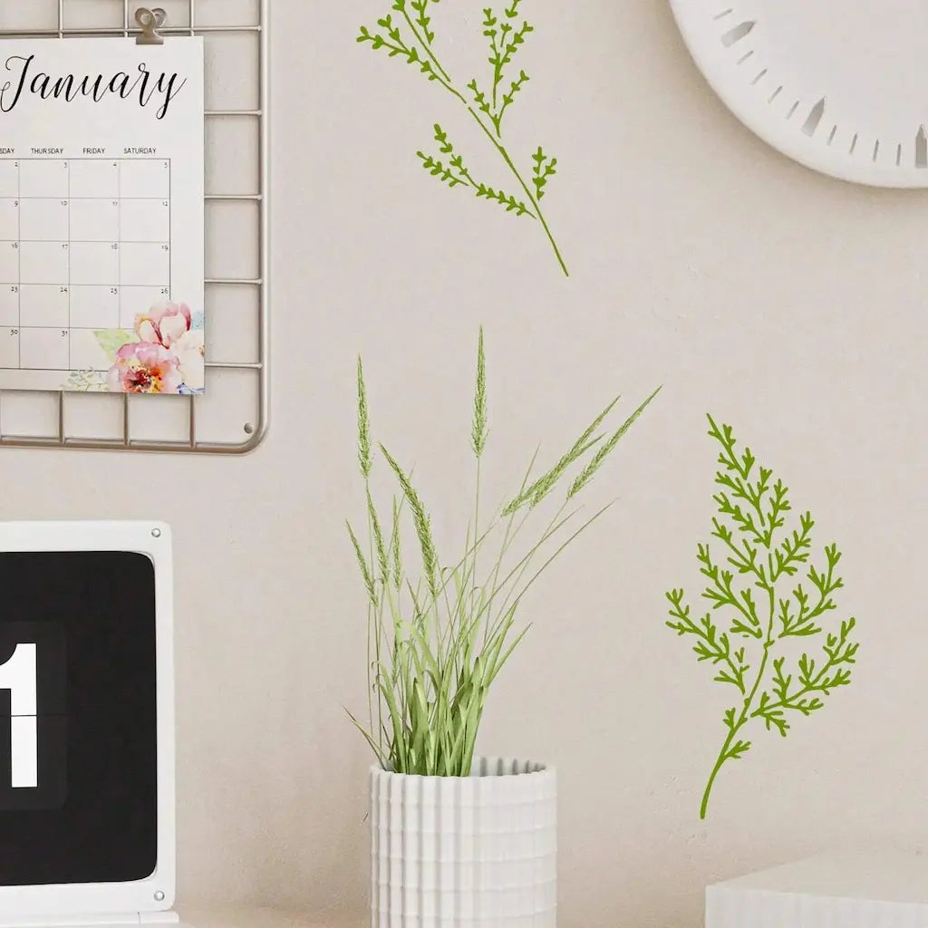 Pochoir imperméable branches vertes peintes au mur, calendrier janvier et pot blanc