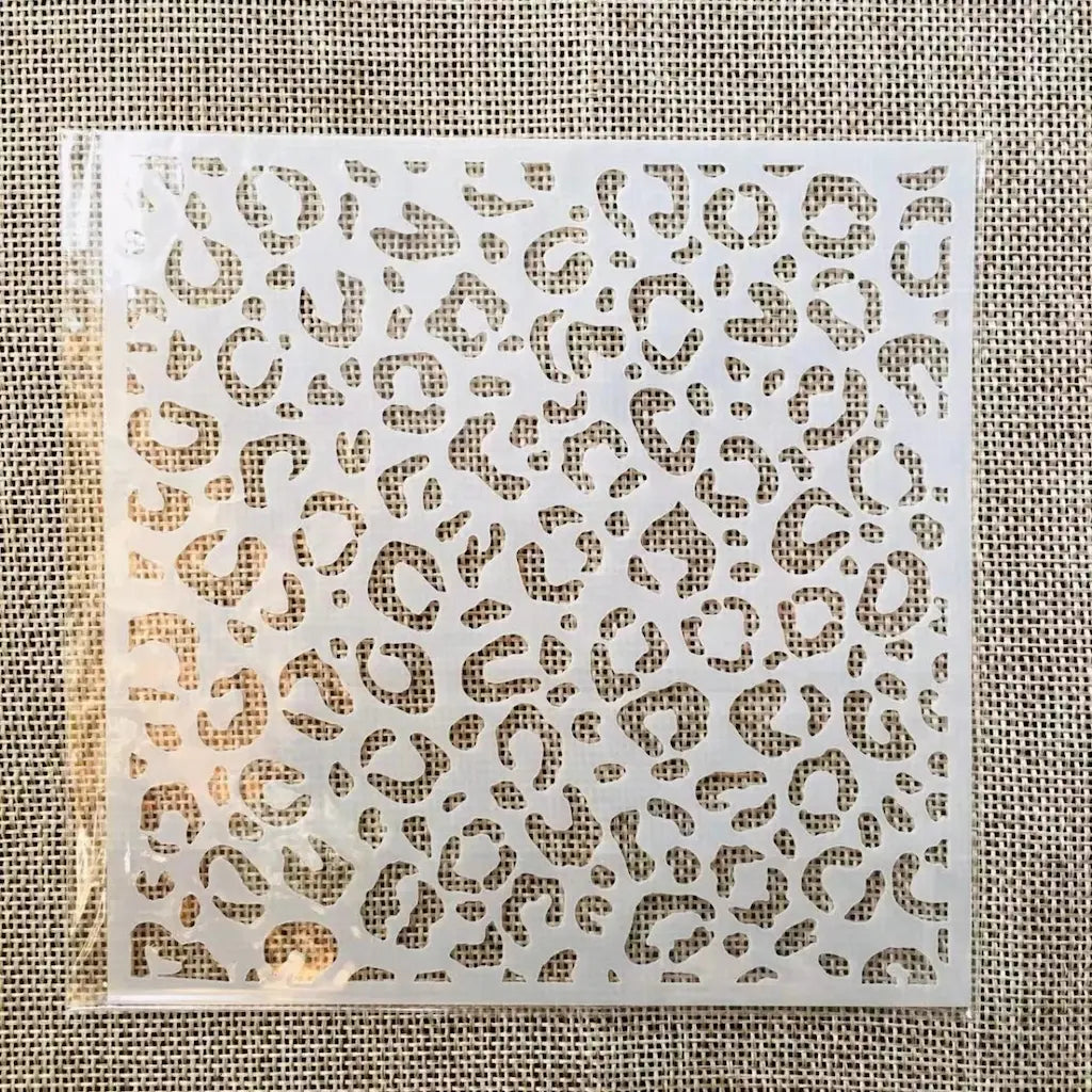 Pochoir léopard motif tacheté répété dense, format carré ajouré sur fond toile de jute beige