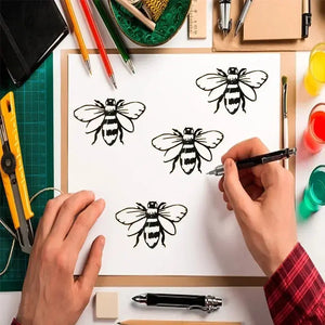 Pochoir nid d'abeille démonstration : 4 abeilles peintes noir sur feuille, atelier crayons