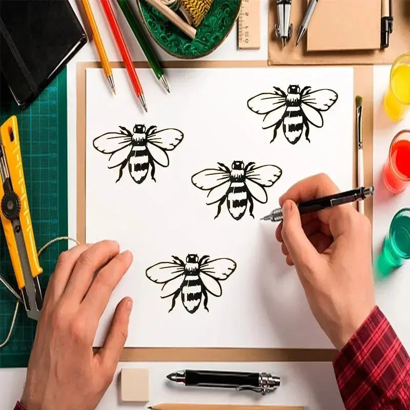 Pochoir nid d'abeille démonstration : 4 abeilles peintes noir sur feuille, atelier crayons