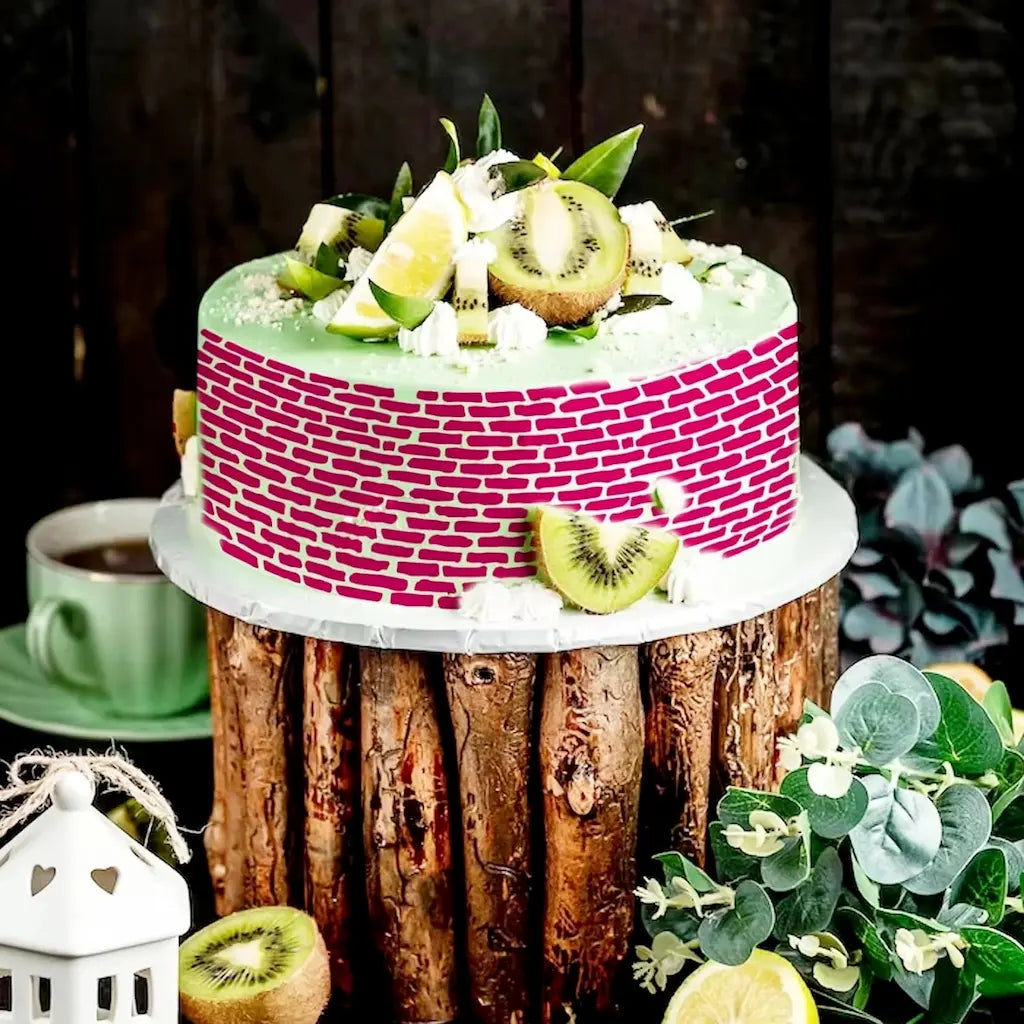 Pochoir texture brique magenta sur gâteau vert pâle, kiwis et citron en décor pâtissier