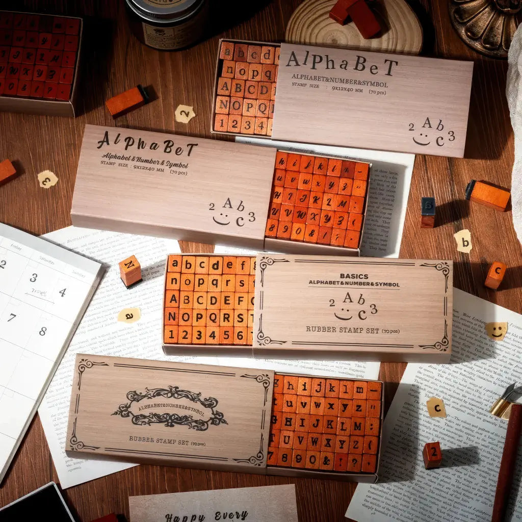 Tampon alphabet scrapbooking, plusieurs coffrets de polices posés sur un bureau