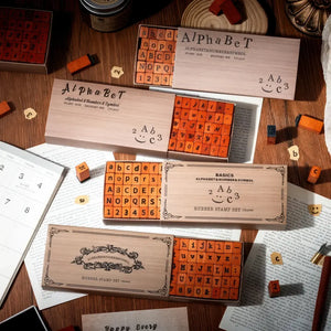 Tampon alphabet scrapbooking, plusieurs coffrets de polices posés sur un bureau