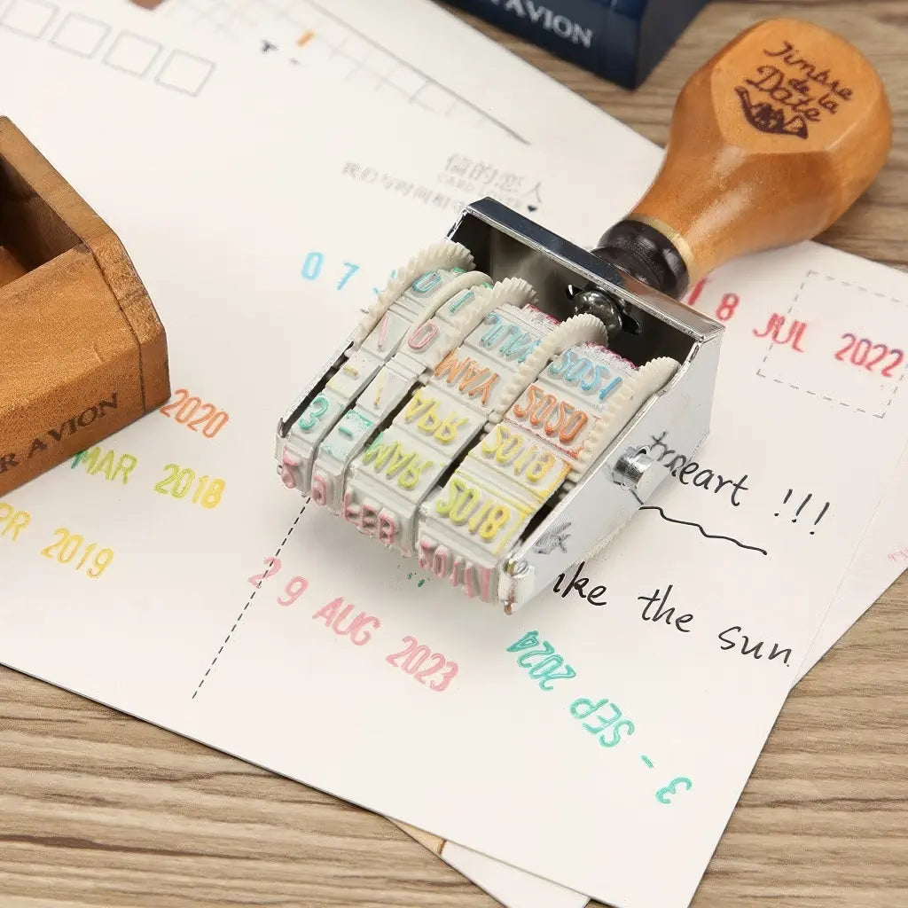 Tampon dateur scrapbooking en action, dates imprimées en plusieurs couleurs sur papier