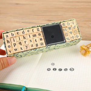 Tampon écriture scrapbooking, coffret de mini-lettres et encreur sur un carnet pointillé