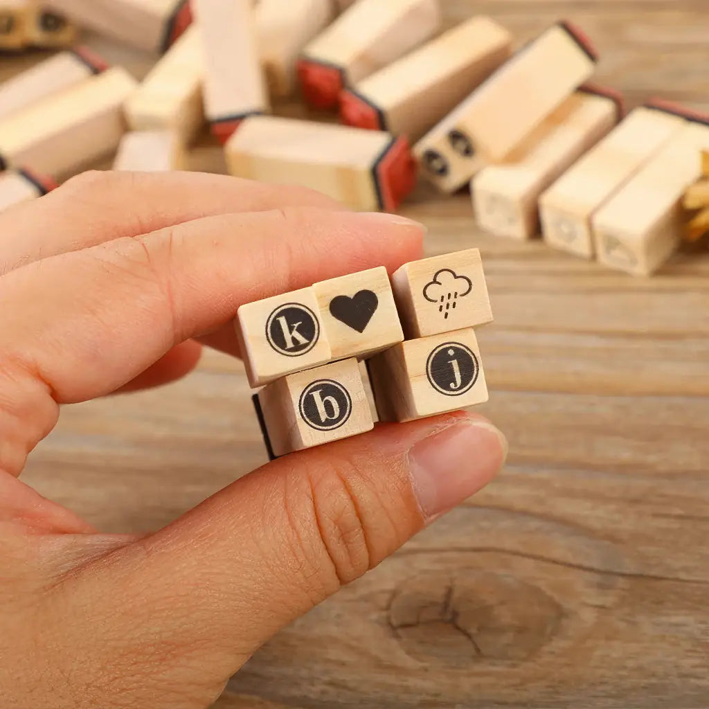 Tampon écriture scrapbooking, gros plan de mini-tampons lettres et symboles en main