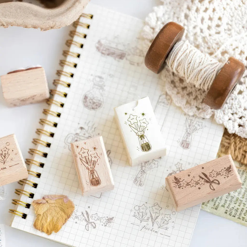 Tampon scrapbooking Endroit Magique, tampons en bois et empreintes sur un carnet quadrillé