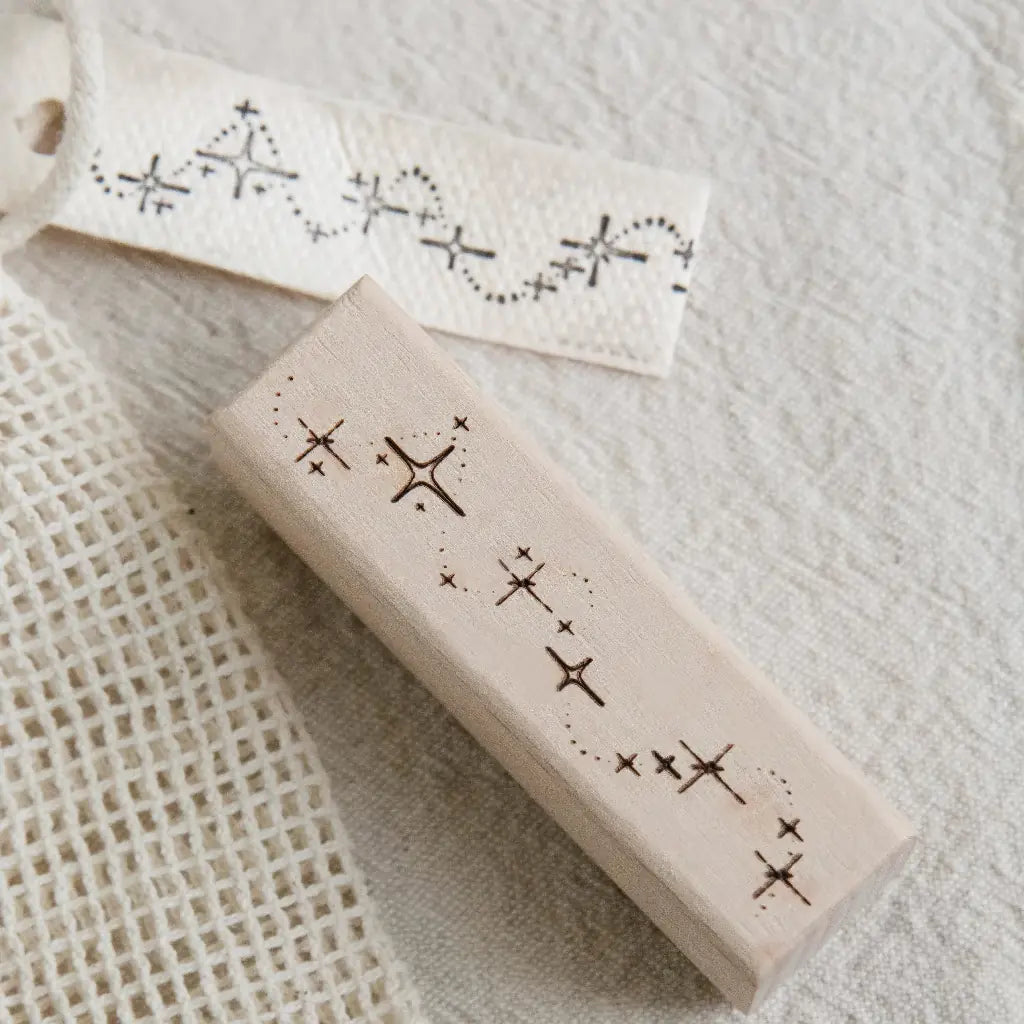 Gros plan d'un tampon Nuit Magique scrapbooking, traînée d'étoiles gravée et son empreinte