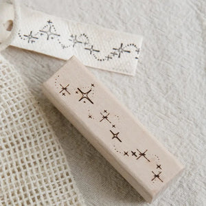 Gros plan d'un tampon Nuit Magique scrapbooking, traînée d'étoiles gravée et son empreinte